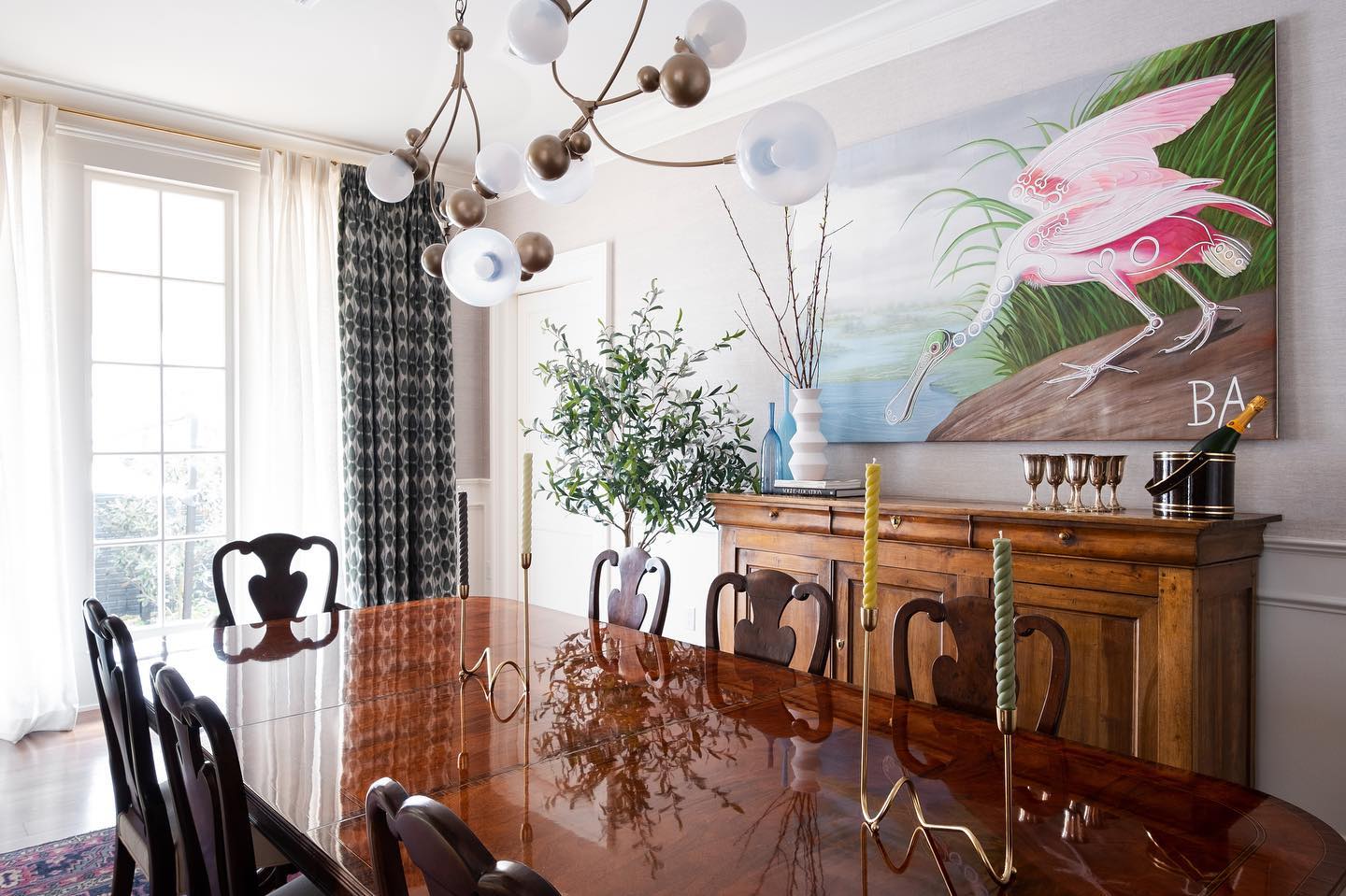 Dining room with a French walnut sideboard from DOP Antiques beneath a large roseate spoonbill painting