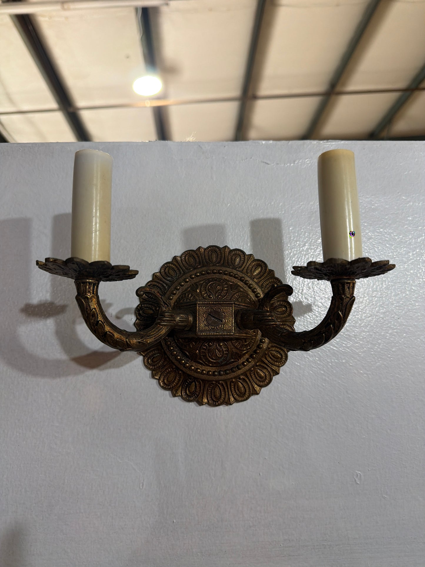 Neoclassical / Federal Revival two-light wall sconces with beaded rosette backplates, circa 1928–1935.